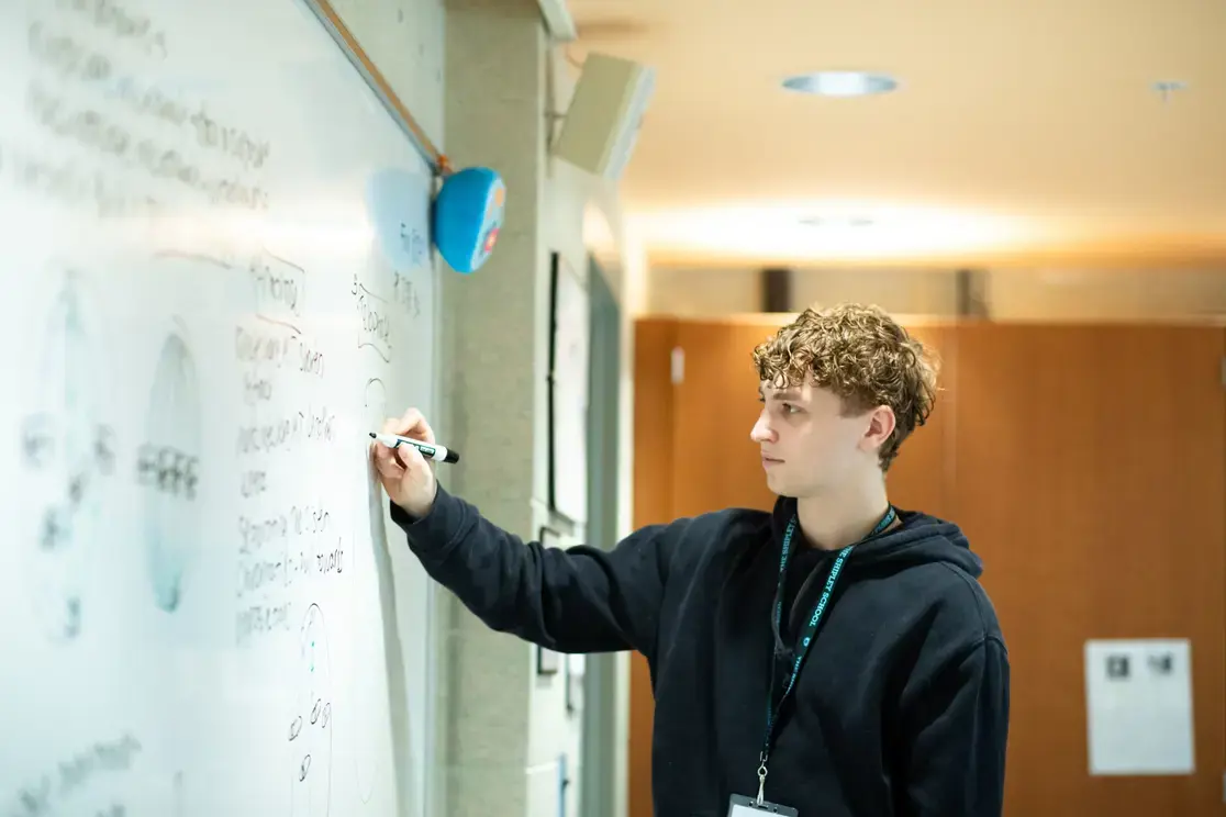 Teacher writing on whiteboard