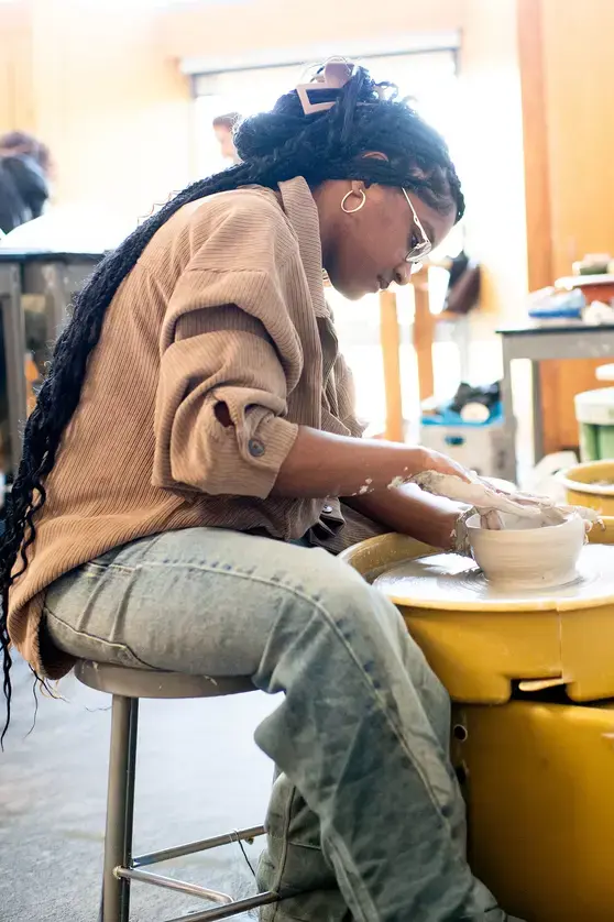 Student throwing pottery