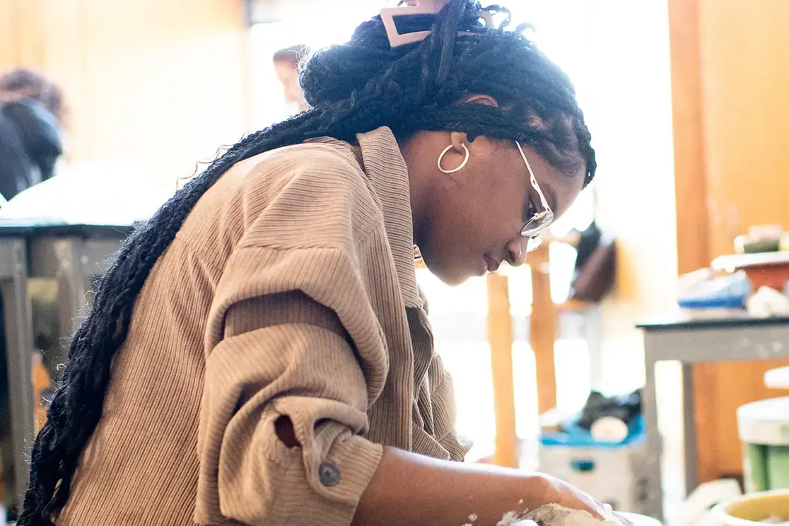 Student throwing pottery