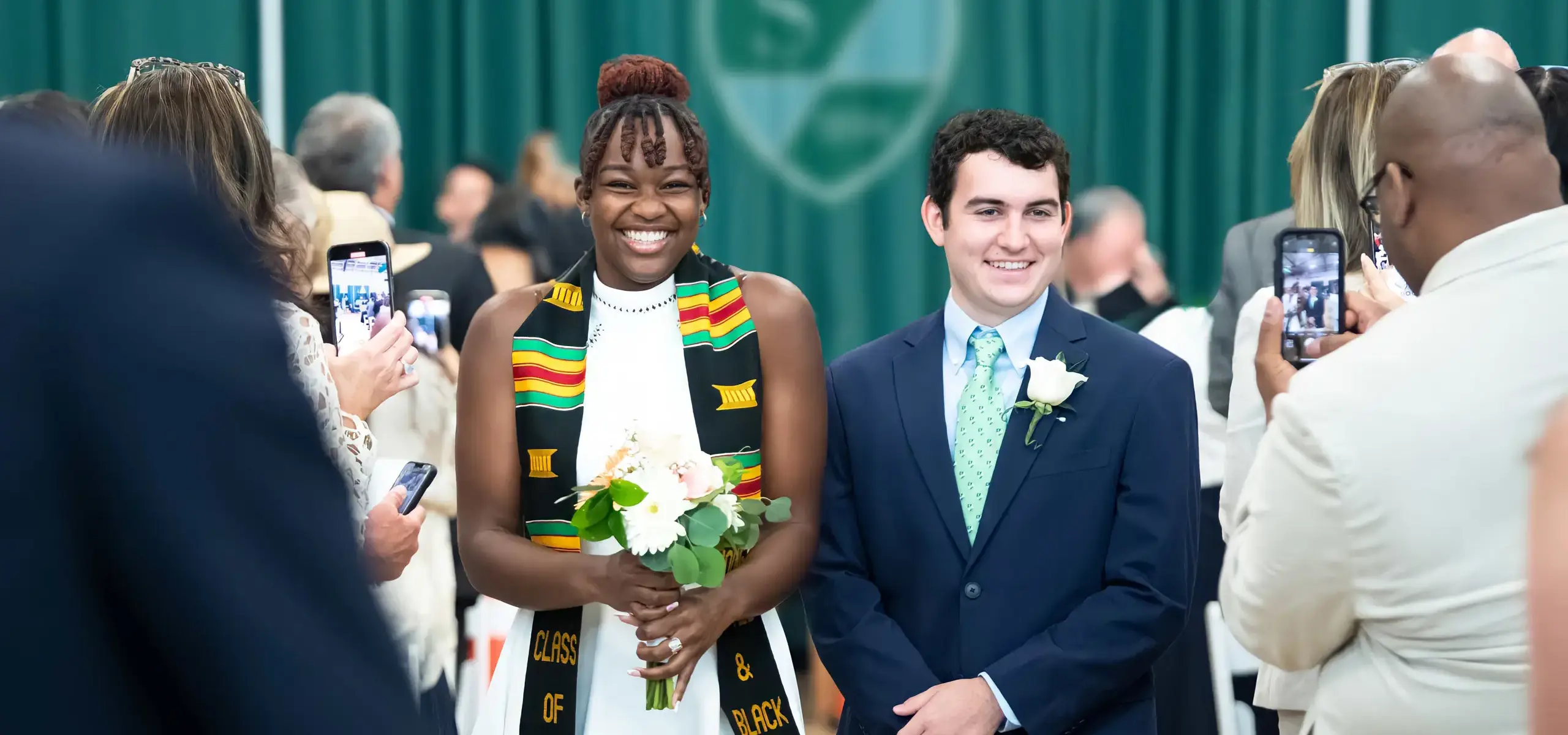 Students at commencment ceremony smiling