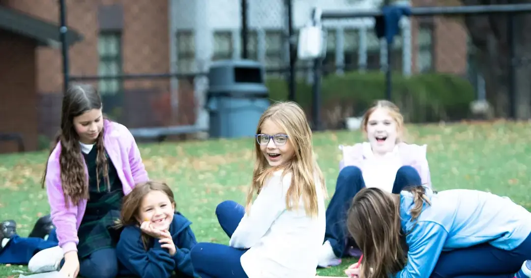 Lower school students sat in field smiling