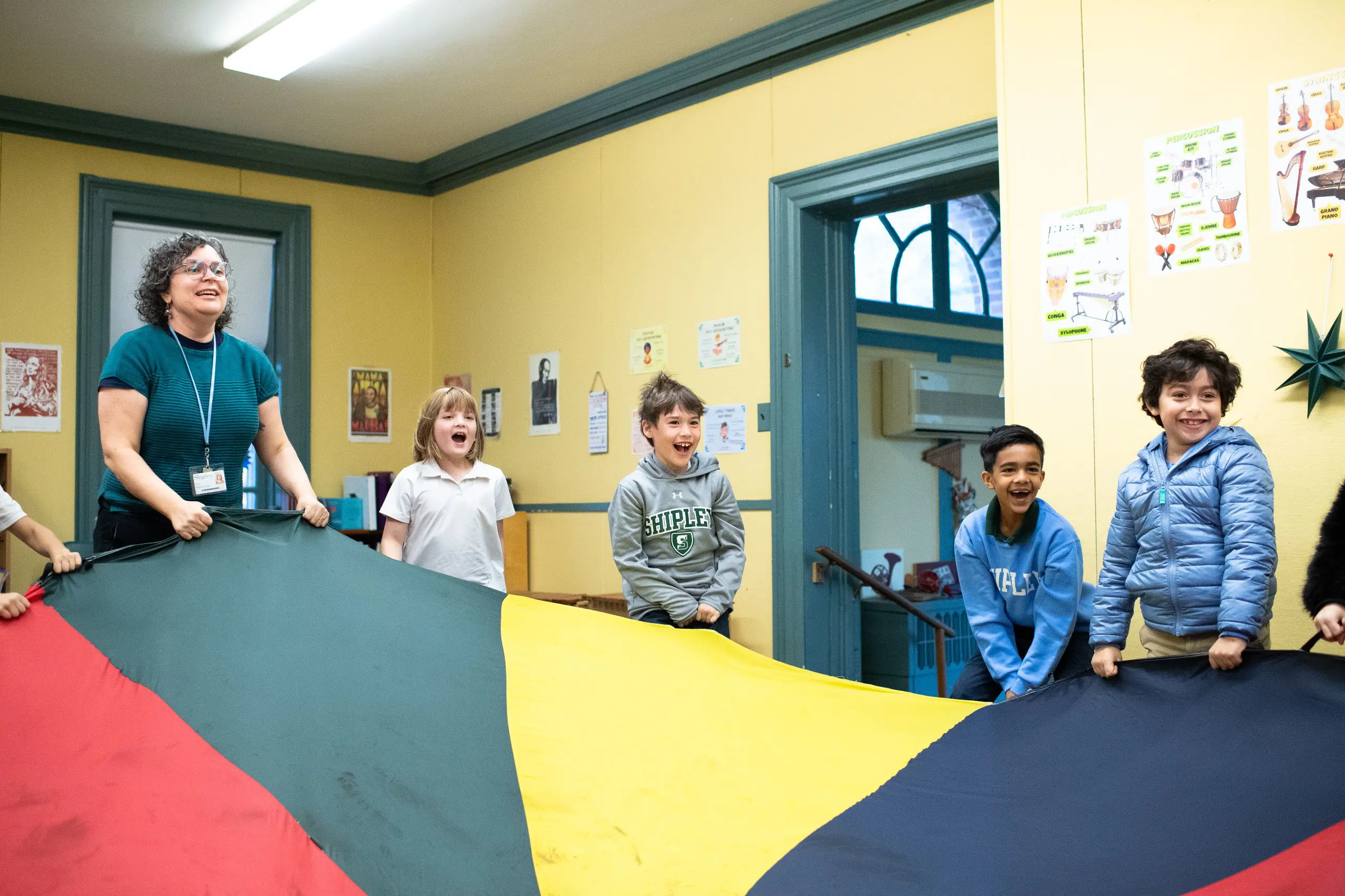 Lower school student playing with parachute in class