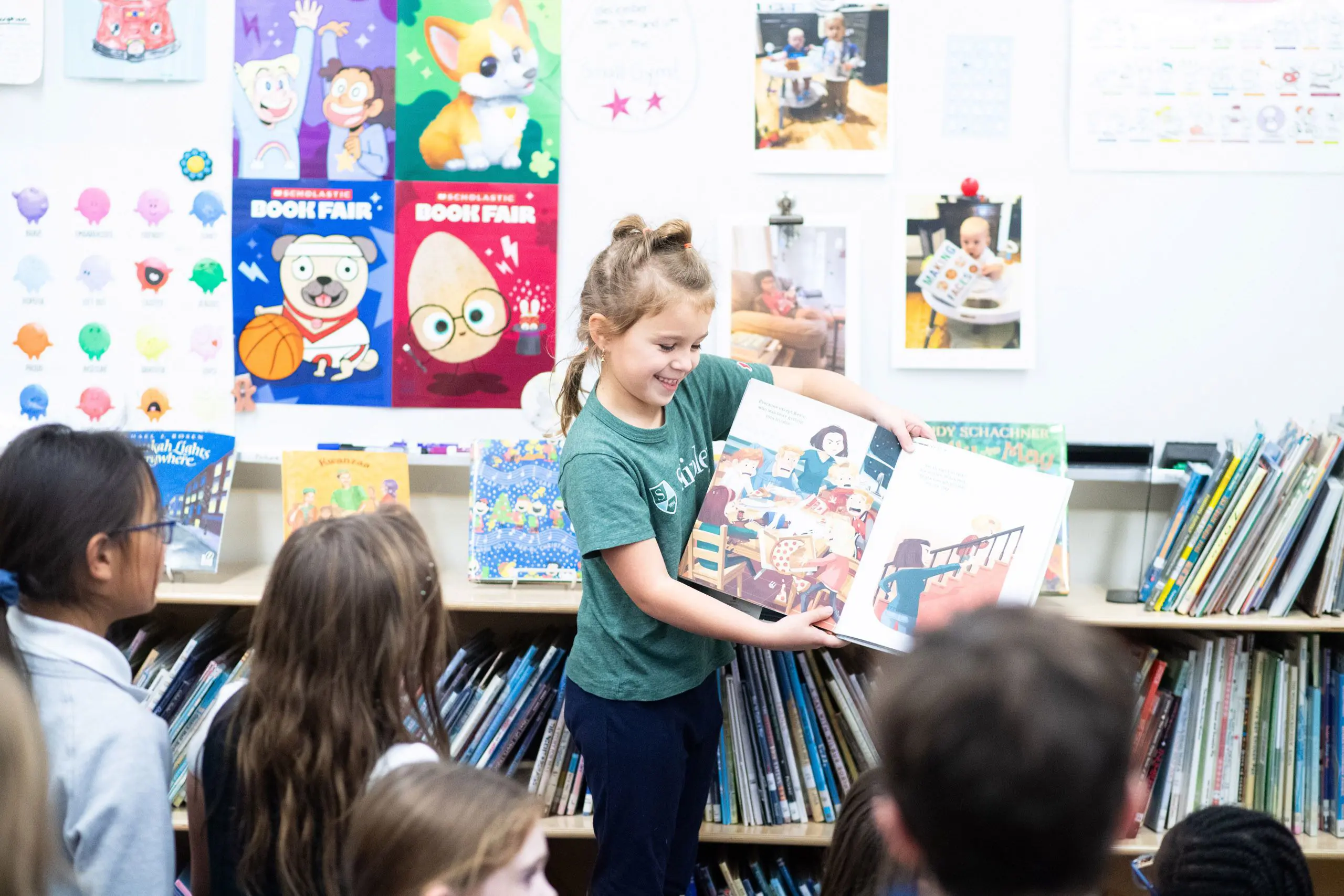 Lower school student reading book to classmates