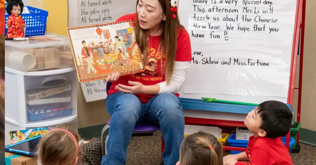 Upper school student reading lower school student book