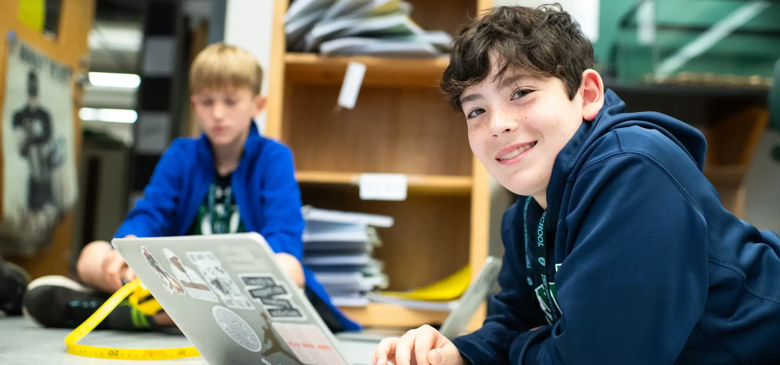 Middle school students doing class work on laptop
