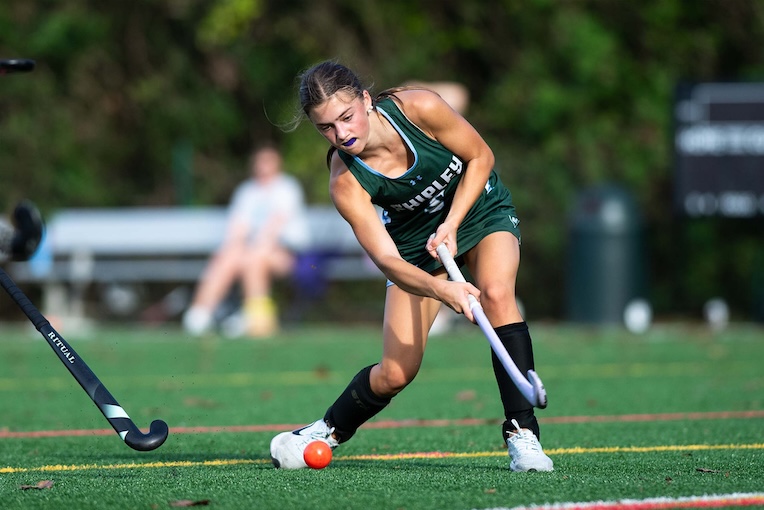 girl playing field hockey on turf at The Shipley School