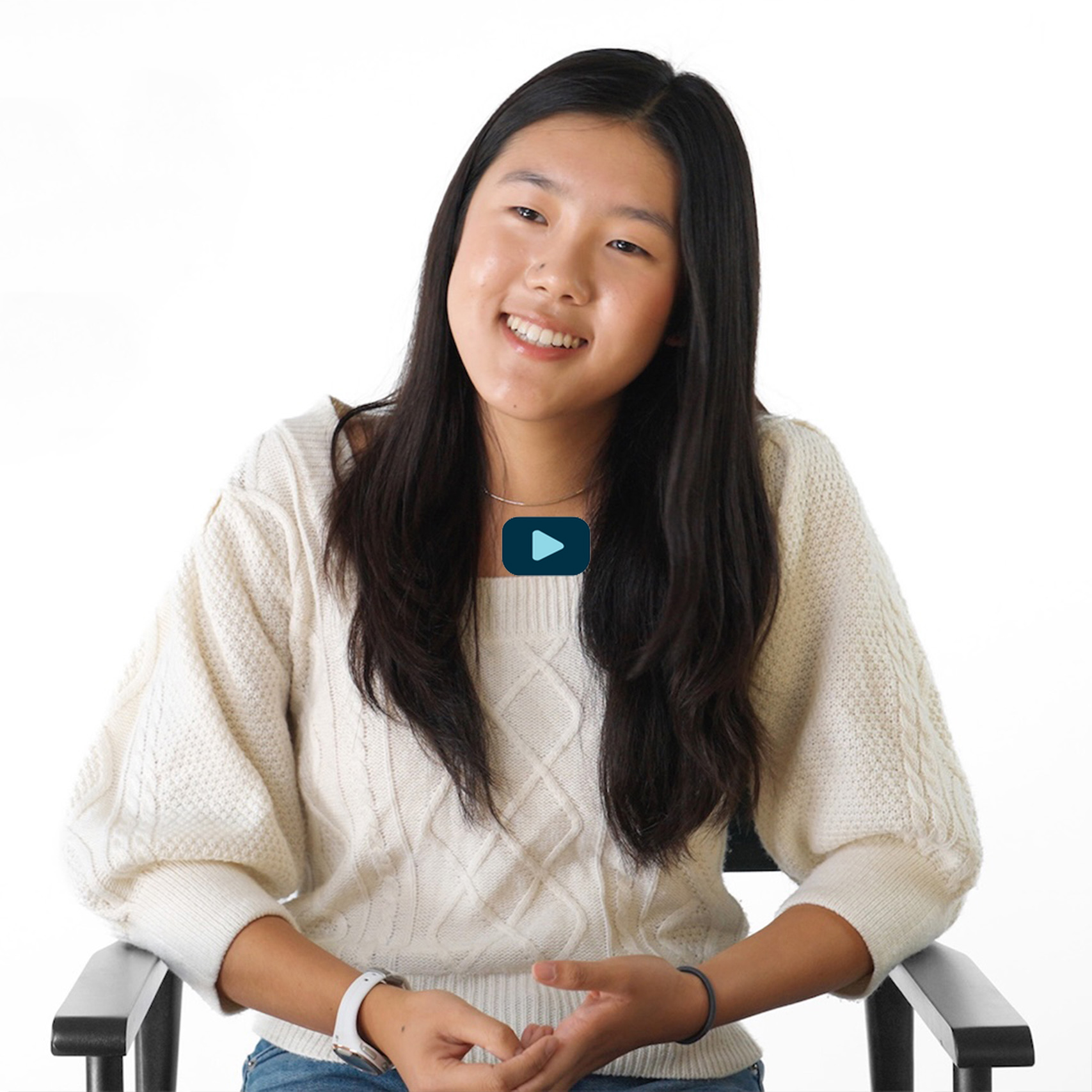 photo of Phoebe smiling in chair, with play button
