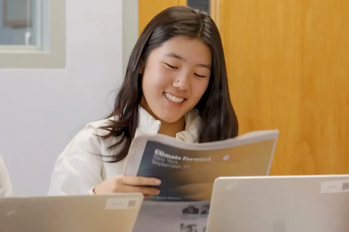 Student reading books and smiling