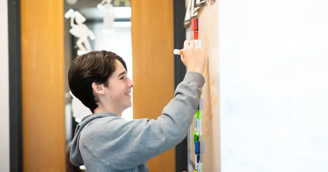 Student writing on whiteboard