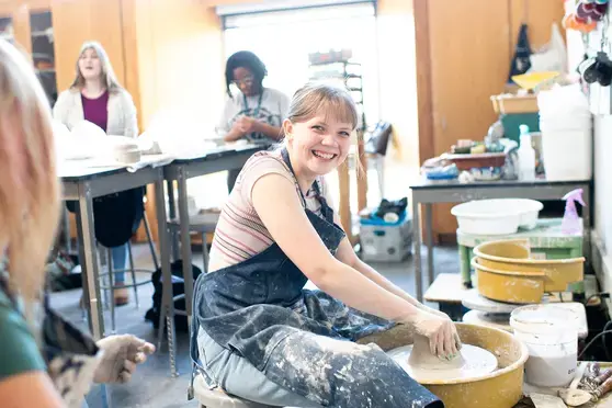 Student throwing pottery