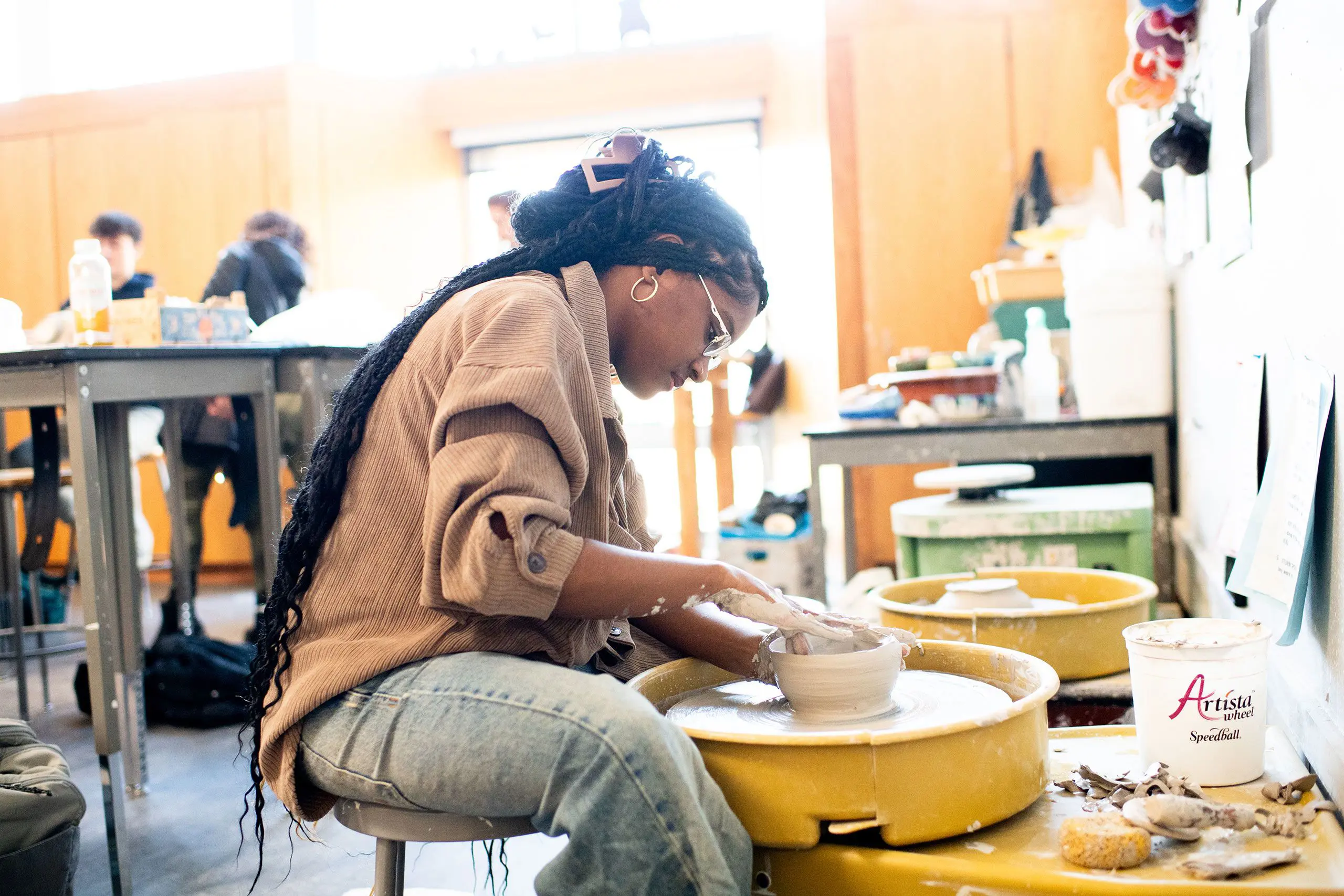 Student throwing pottery