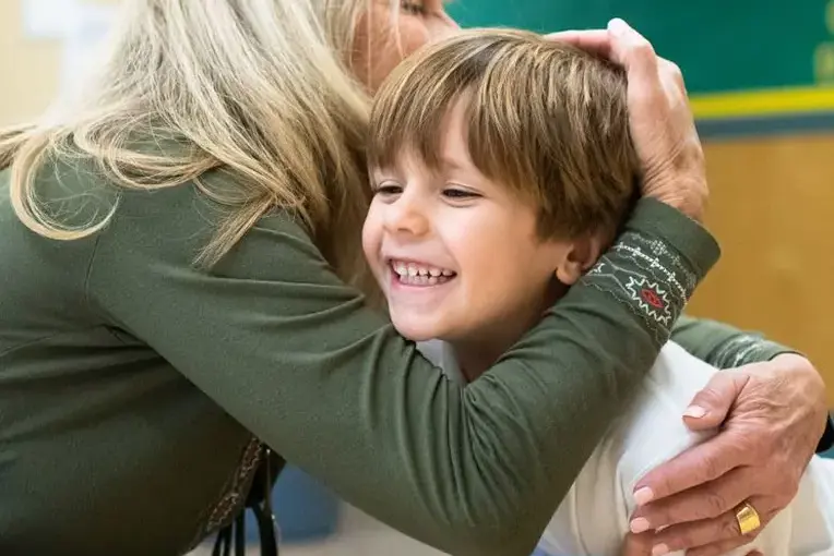 Teacher hugging student