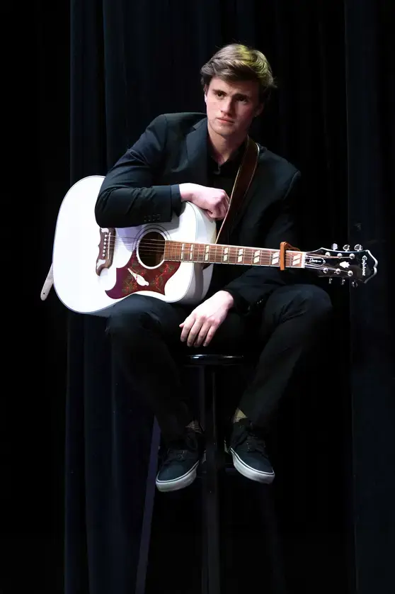 Student holding guitar