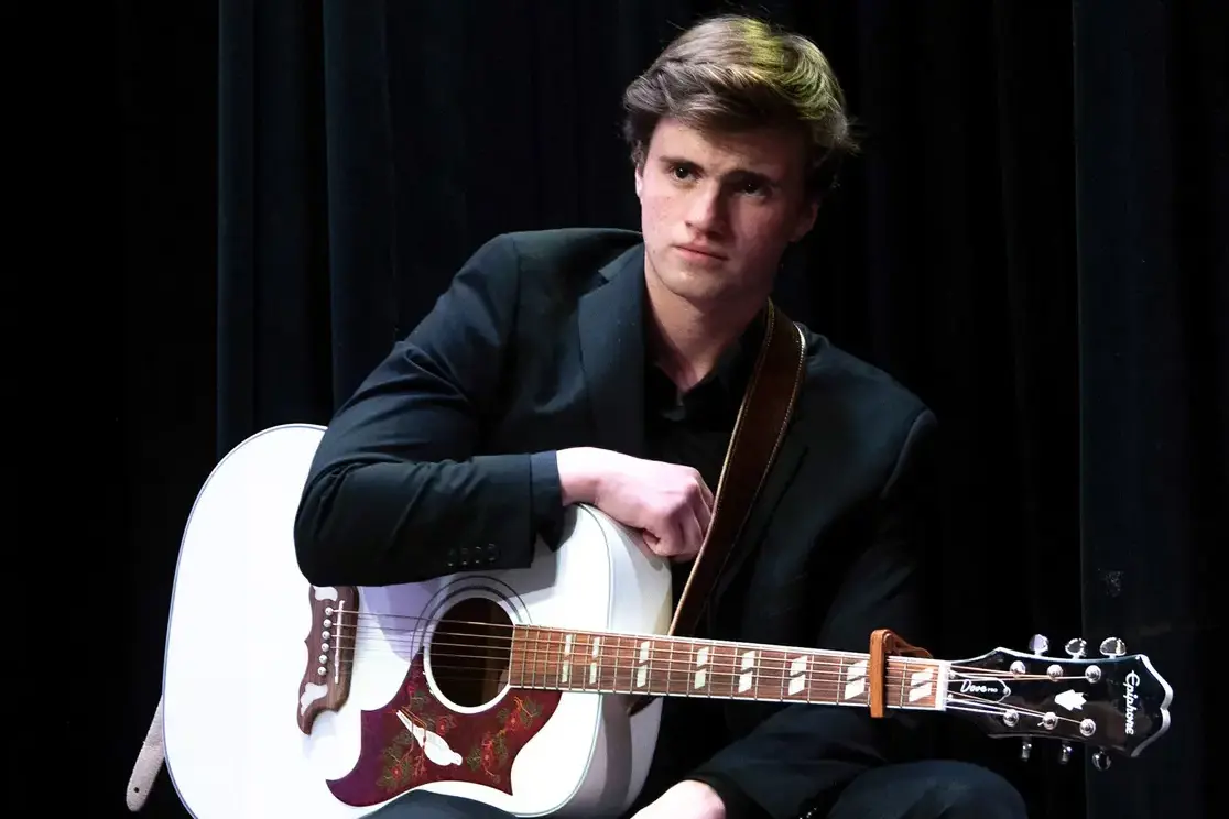 Student holding guitar
