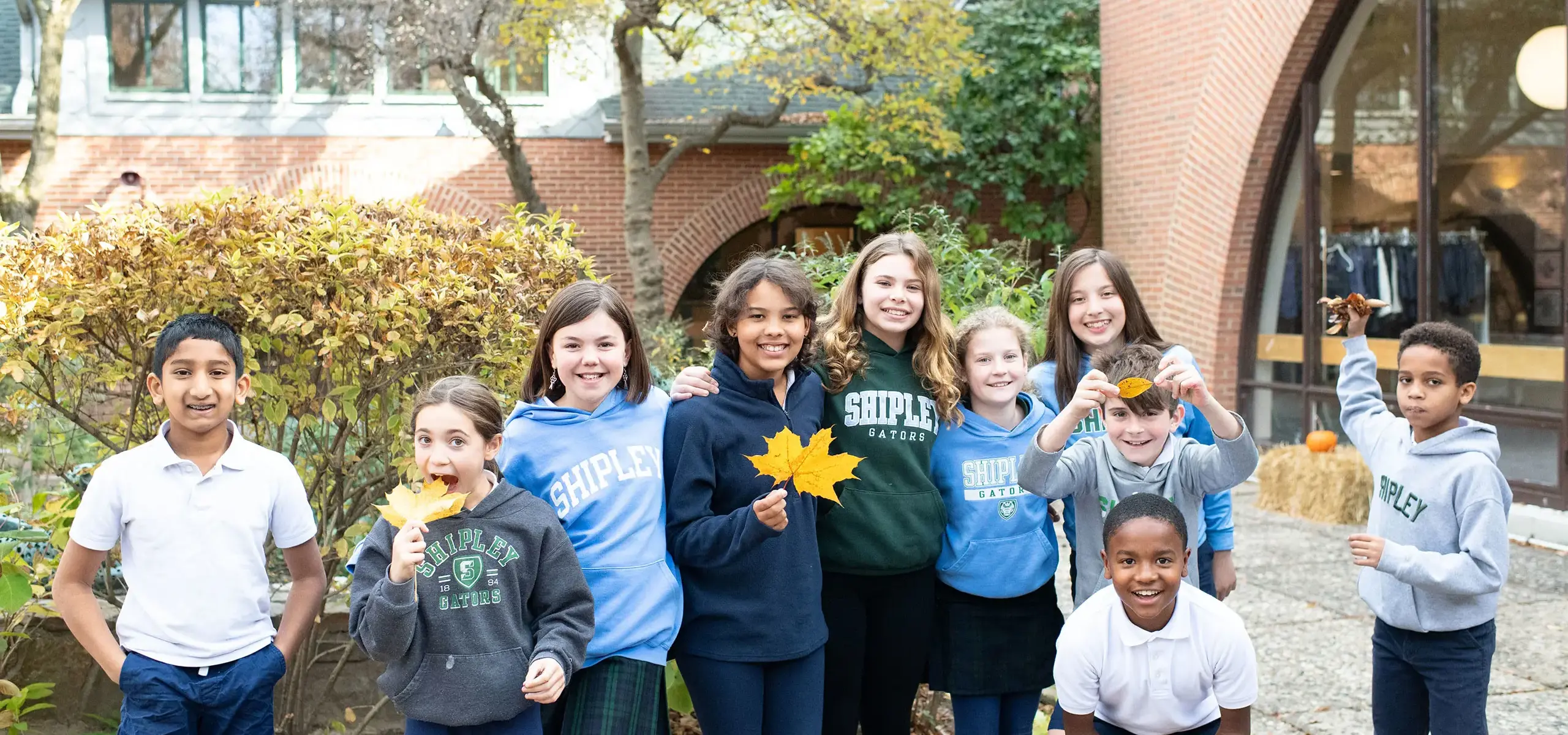Students holding fall leaves