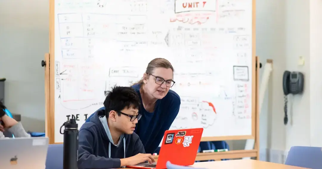 Teacher assisting student in class