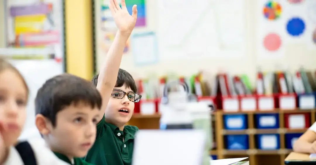 Student raising hand in classroom