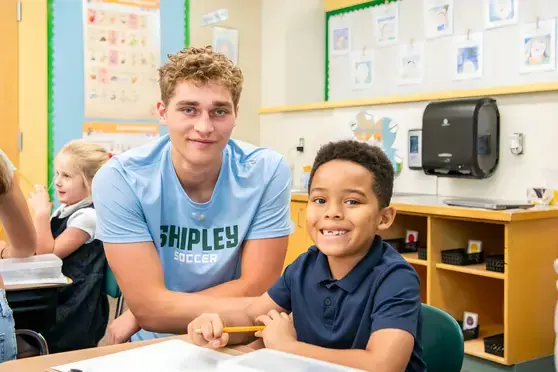 Upper school student helping lower school student
